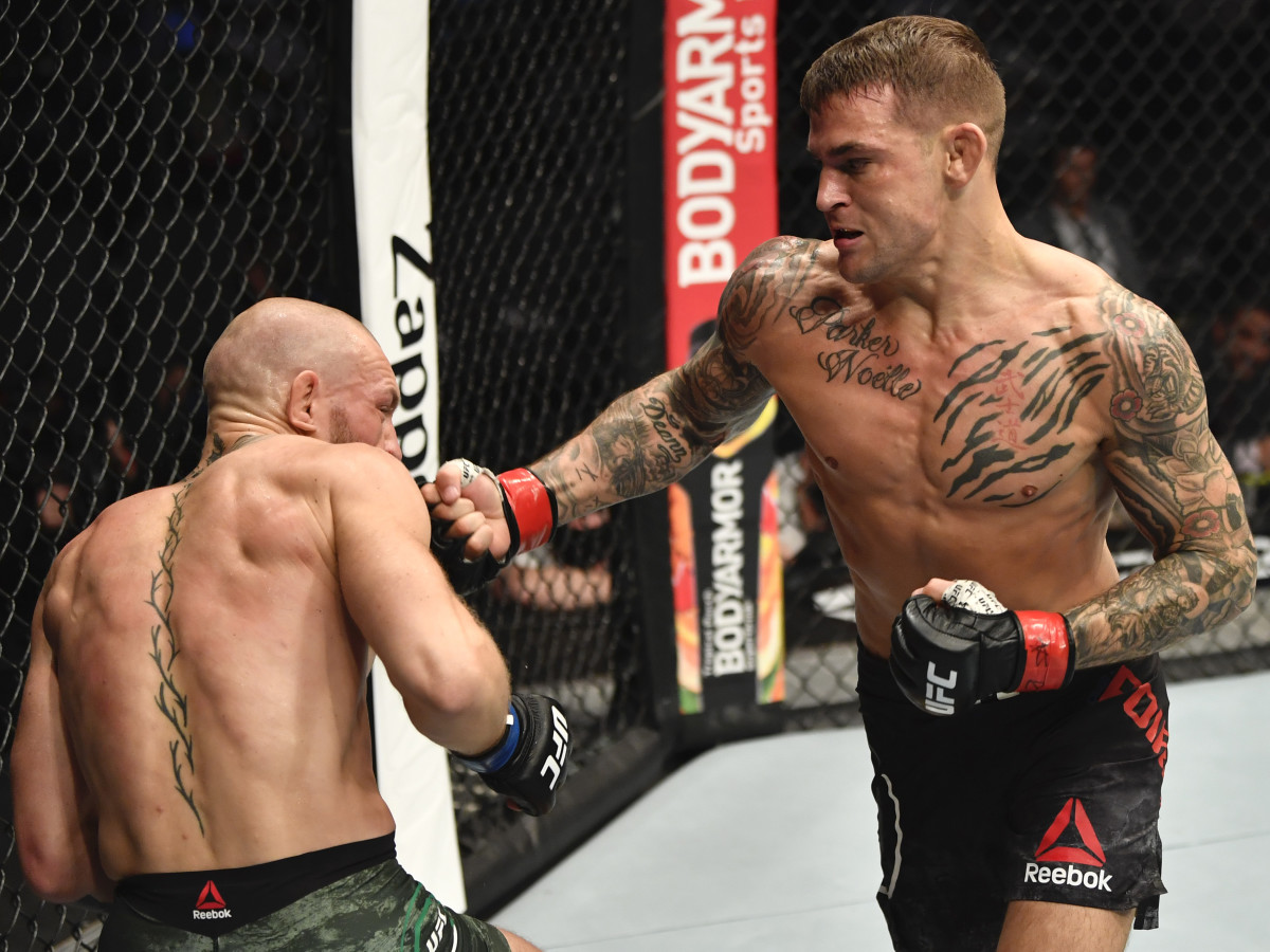 Dustin Poirier punches Conor McGregor of Ireland in a lightweight fight during the UFC 257 event inside Etihad Arena on UFC Fight Island.