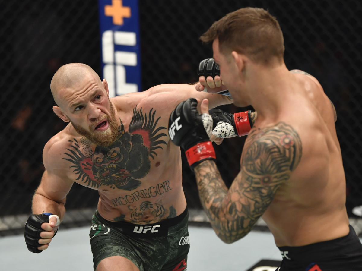 Conor McGregor of Ireland punches Dustin Poirier in a lightweight fight during the UFC 257 event inside Etihad Arena on UFC Fight Island.