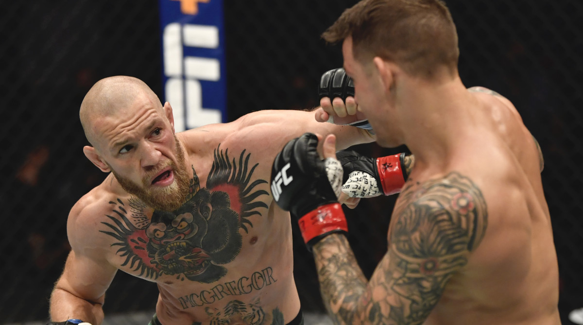 Conor McGregor of Ireland punches Dustin Poirier in a lightweight fight during the UFC 257 event inside Etihad Arena on UFC Fight Island.