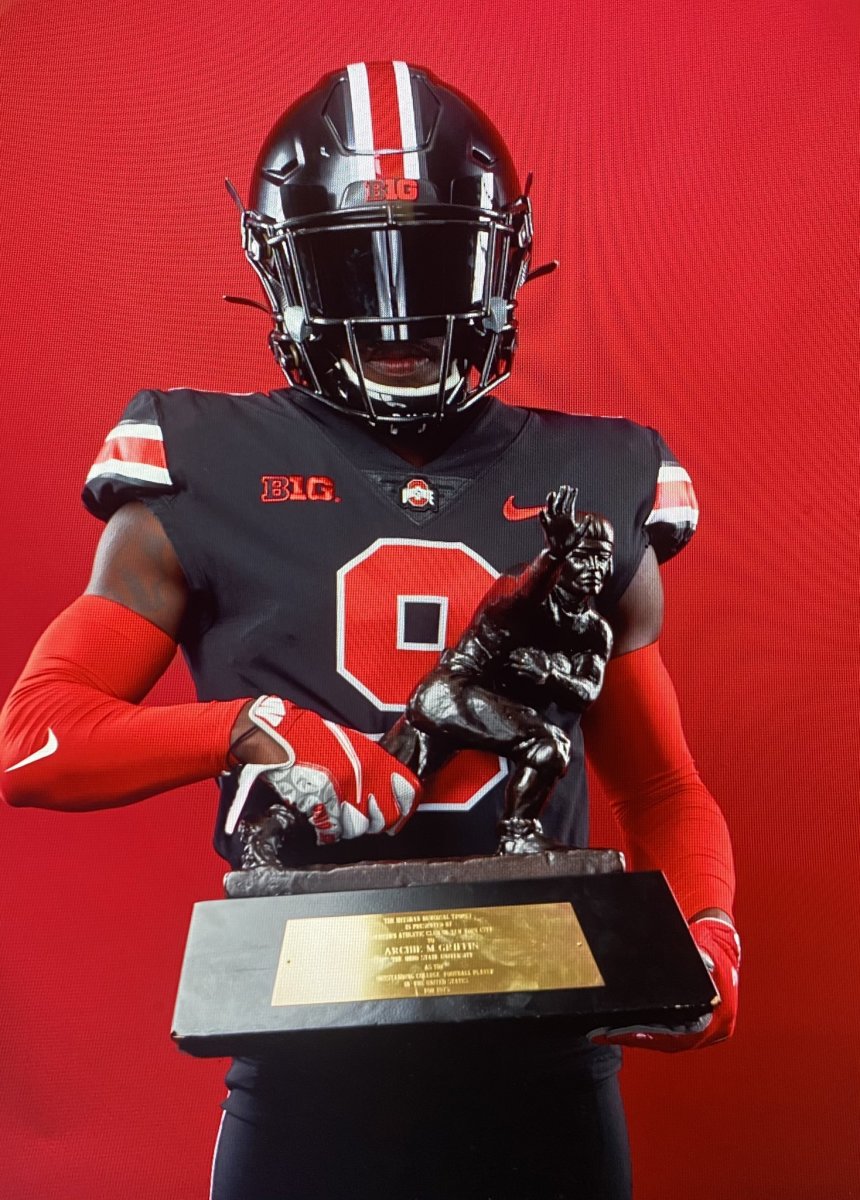 Young holds Archie Griffin's Heisman trophy during his Ohio State visit.