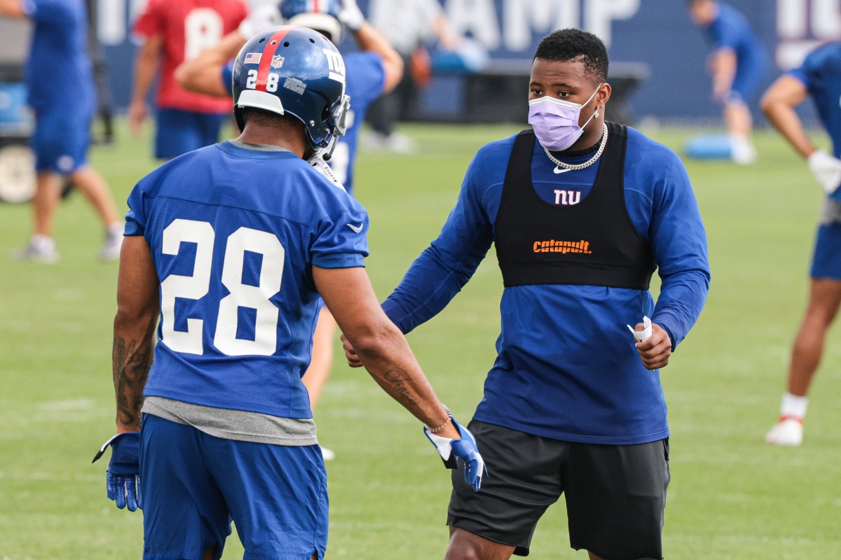 Jul 29, 2021; East Rutherford, NJ, USA; New York Giants running back Saquon Barkley (right) talks with running back Devontae Booker (28) during training camp at Quest Diagnostics Training Center.