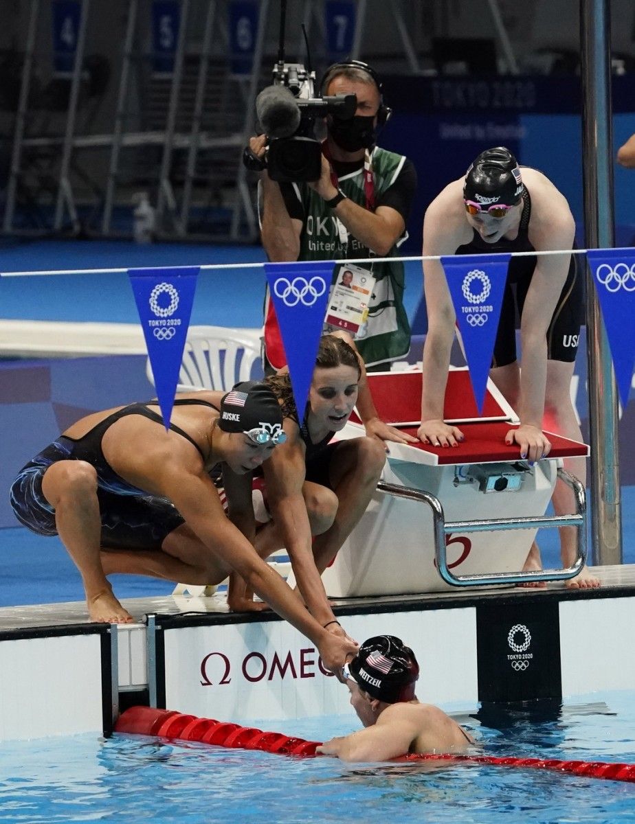Exhausted Abbey Weitzeil is helped out of the pool after the medley relay final. Photo by Rob Schumacher, USA Today