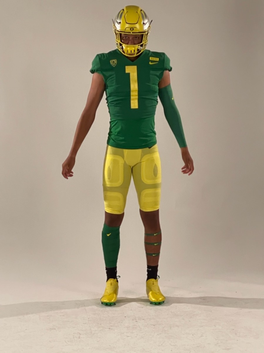 Austin Mack takes photos in the Ducks' apple green and yellow uniforms.
