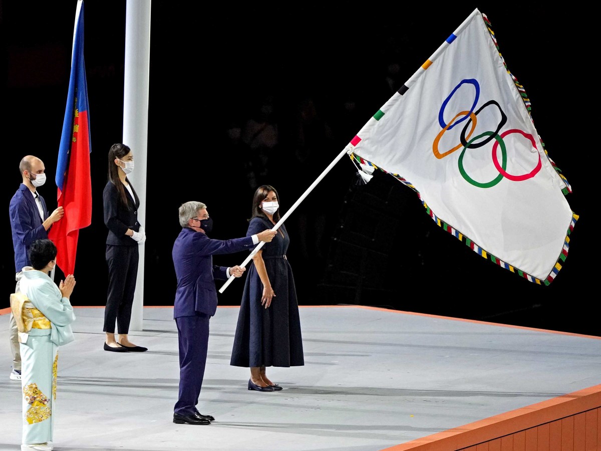 IOC president Thomas Bach waves the Olympic flag during the closing ceremony for the Tokyo 2020 Olympic Summer Games at Olympic Stadium.