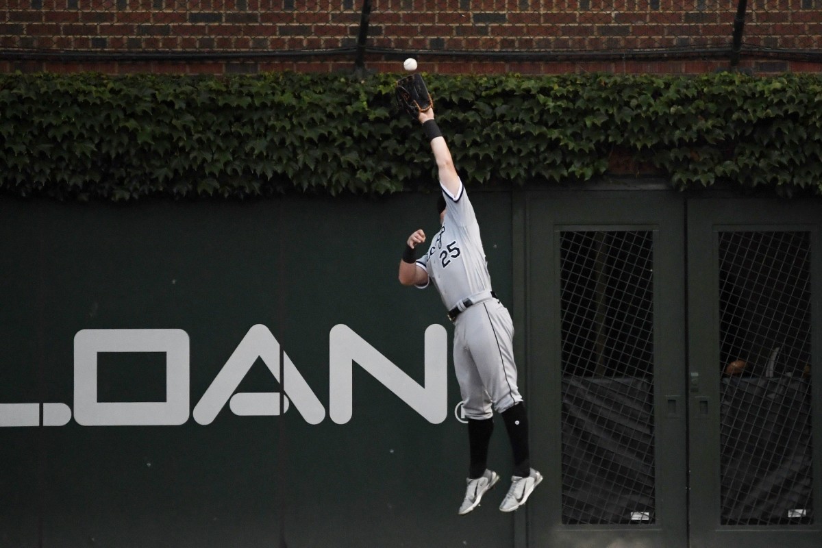 Andrew Vaughn goes high against the right-field wall to make the catch.