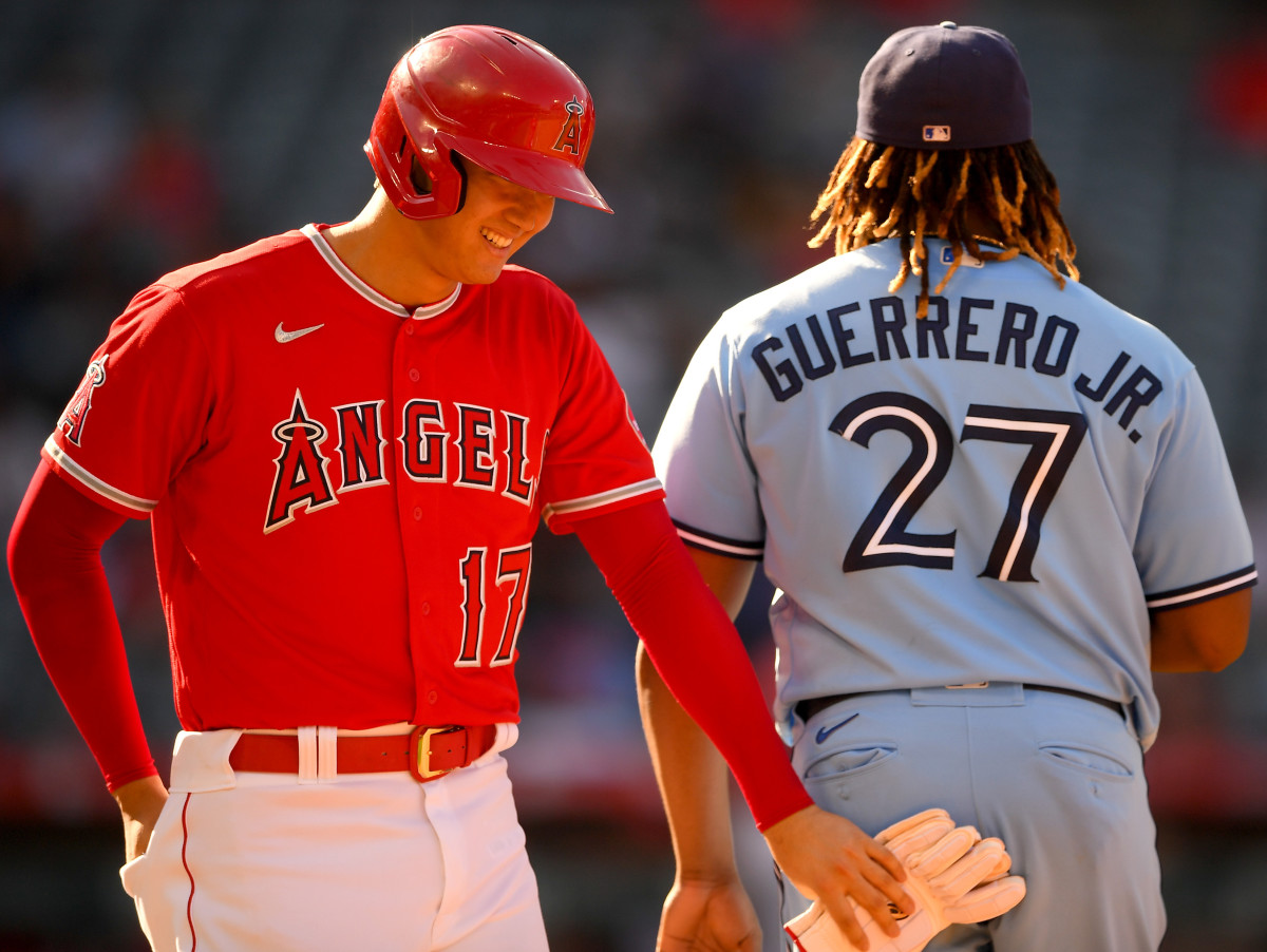 Los Angeles Angels designated hitter Shohei Ohtani (17) smiles at Toronto Blue Jays first baseman Vladimir Guerrero Jr. (27) after drawing an intentional walk in the sixth inning at Angel Stadium.