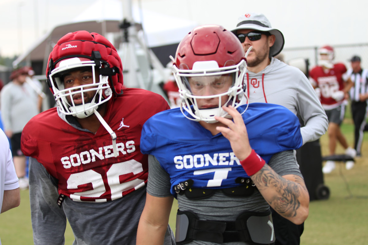 Kennedy Brooks (left), seen standing beside Spencer Rattler, equipped with a Guardian Cap at practice last week.