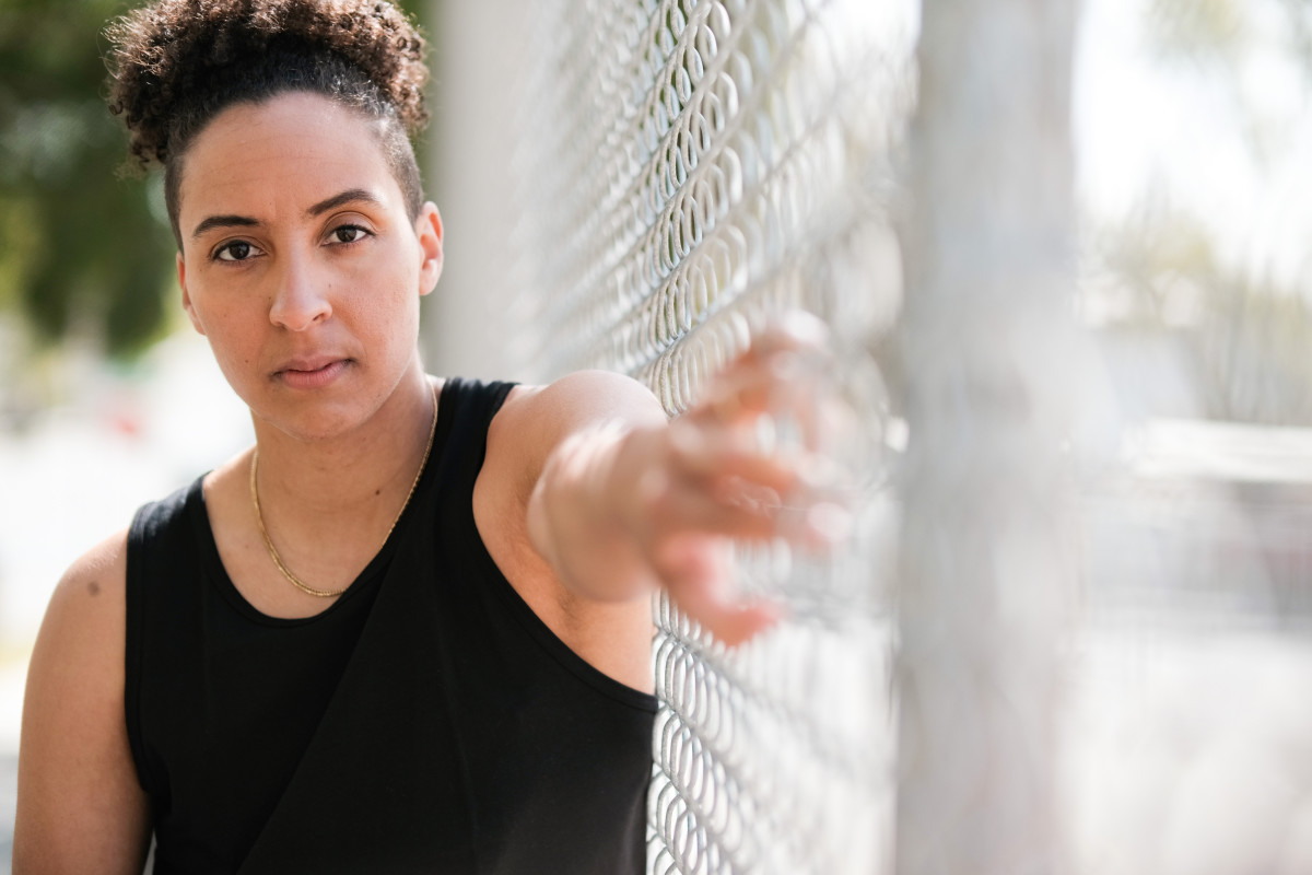 Layshia Clarendon with her arm pressed against a fence