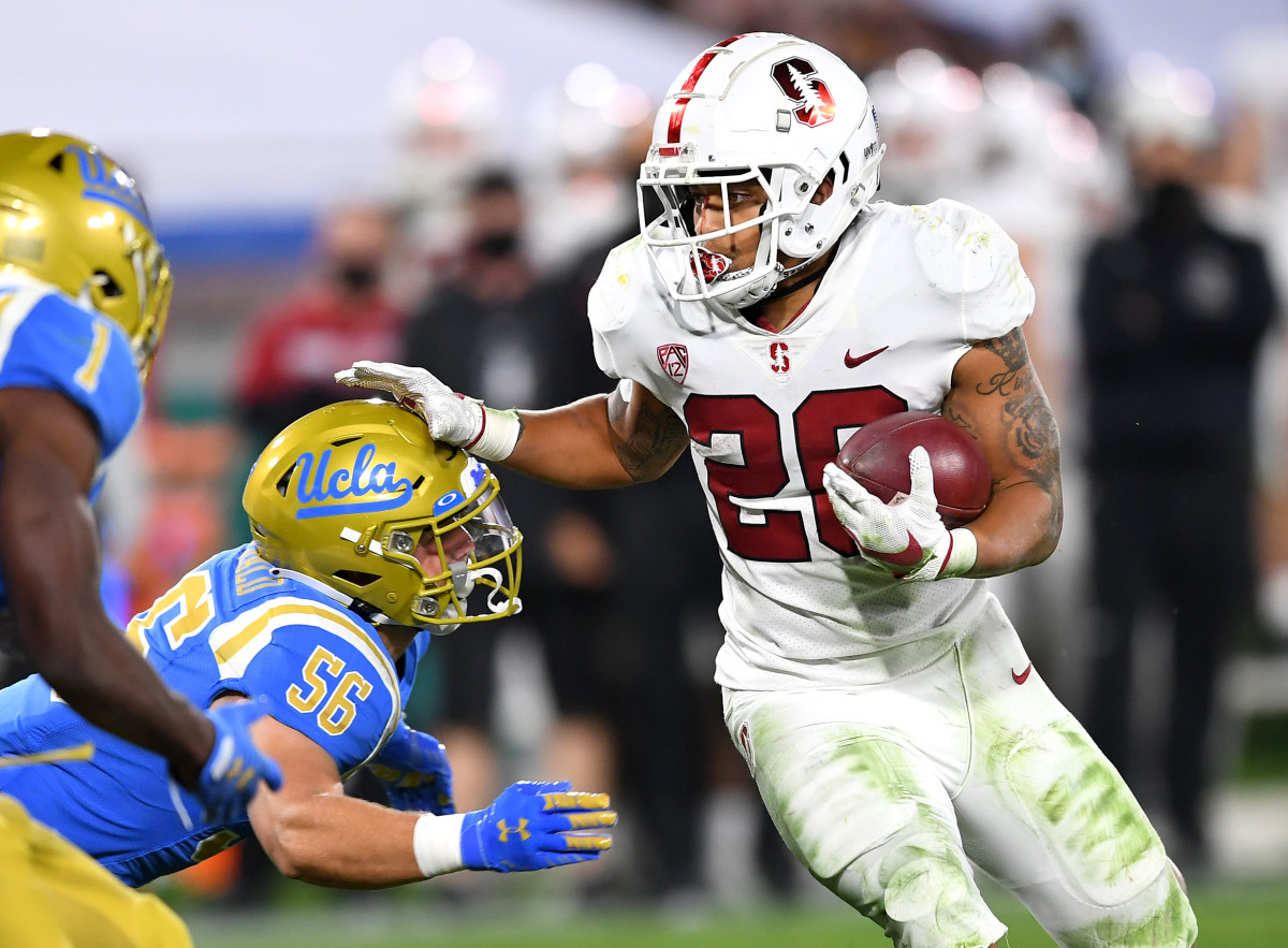 Stanford running back Austin Jones (20) stiff arms UCLA linebacker Kobey Fitzgerald (20) in the Cardinal's 48-47 overtime win over the Bruins on Dec. 19, 2020.