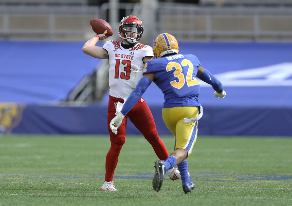 Oct 3, 2020; Pittsburgh, Pennsylvania, USA; North Carolina State Wolfpack quarterback Devin Leary (13) passes against pressure from Pittsburgh Panthers linebacker SirVocea Dennis (32) during the fourth quarter at Heinz Field. The Wolfpack won 30-29.