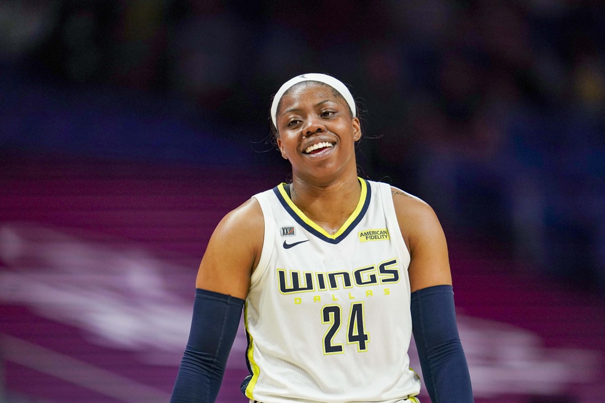 Arike Ogunbowale smiling in a white jersey