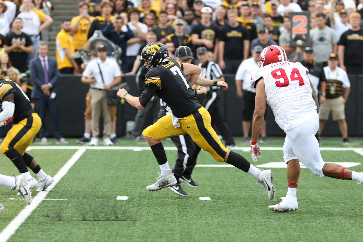 Iowa quarterback Spencer Petras (7) races ahead of Indiana's Demarcus Elliott during a game on Sept. 4, 2021 at Kinnick Stadium.