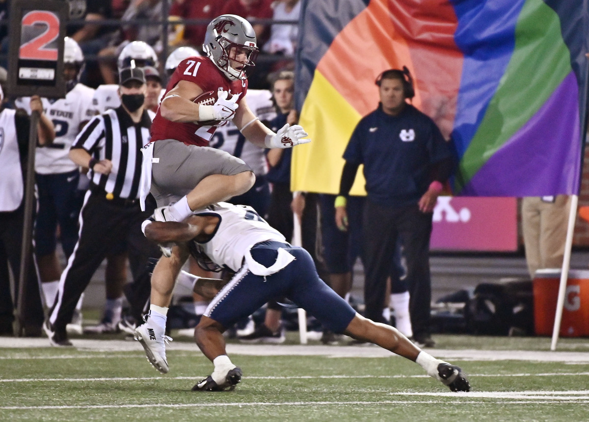Washington State running back Max Borghi (21) tries to jump over Utah State safety Shaq Bond (4).