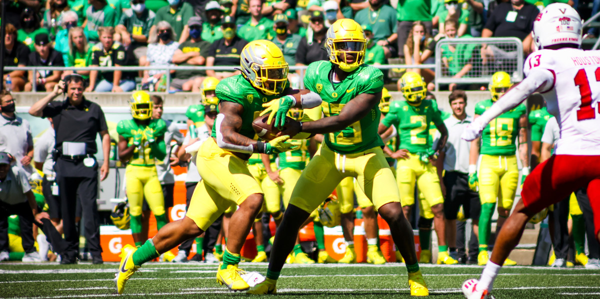 Anthony Brown handing the ball of to Cj Verdell in the 2021 season opener against Fresno State.