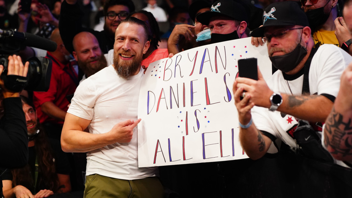 Bryan Danielson poses with a fan’s sign after his AEW debut at "All Out"