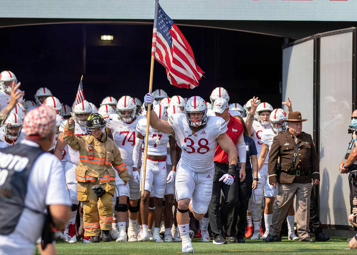 Nebraska linebacker and former Navy SEAL Damian Jackson leads the team and several first responders onto the field.