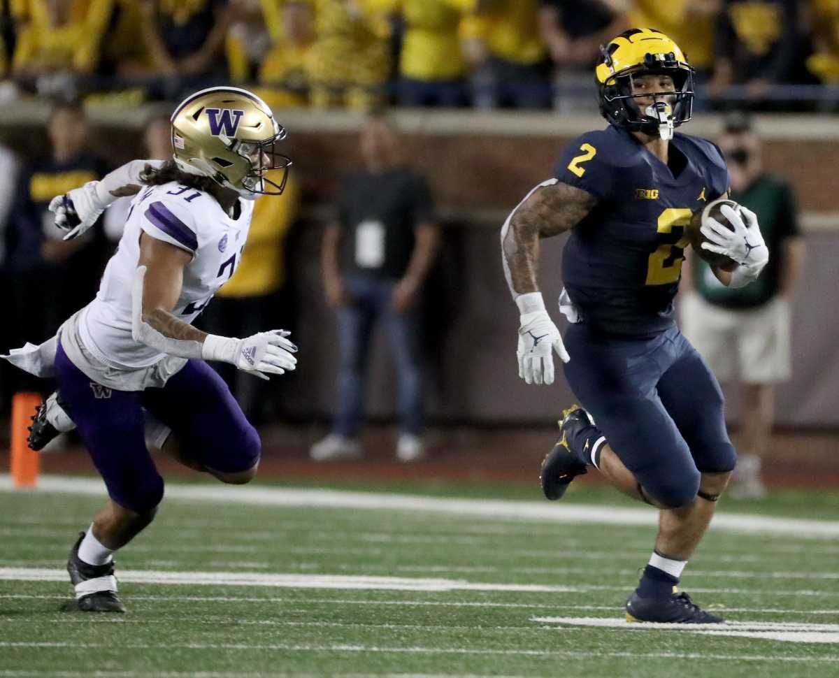 Michigan running back Blake Corum (2) runs by Washington defensive back Kamren Fabiculanan (31) for a touchdown.