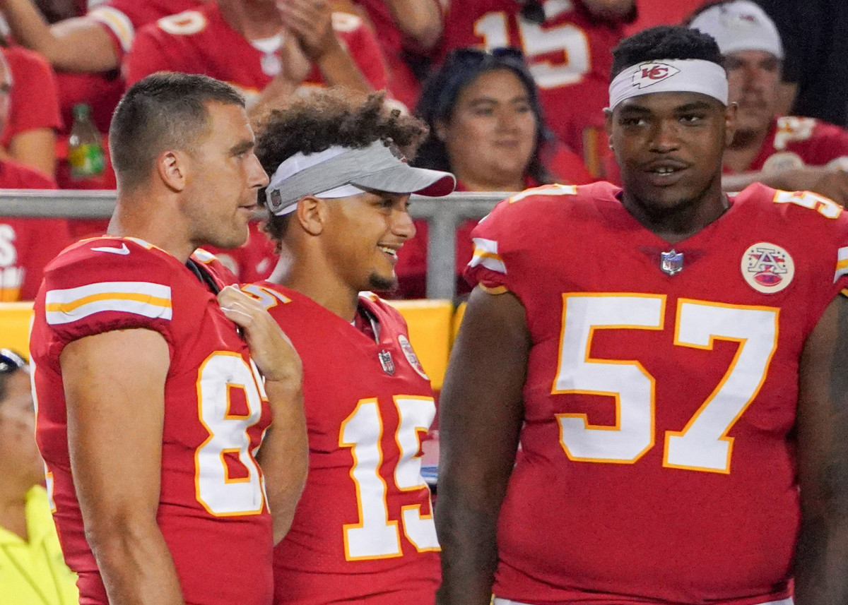 Aug 27, 2021; Kansas City, Missouri, USA; Kansas City Chiefs tight end Travis Kelce (87) and quarterback Patrick Mahomes (15) and offensive tackle Orlando Brown (57) watch play on the sidelines against the Minnesota Vikings during the game at GEHA Field at Arrowhead Stadium. Mandatory Credit: Denny Medley-USA TODAY Sports