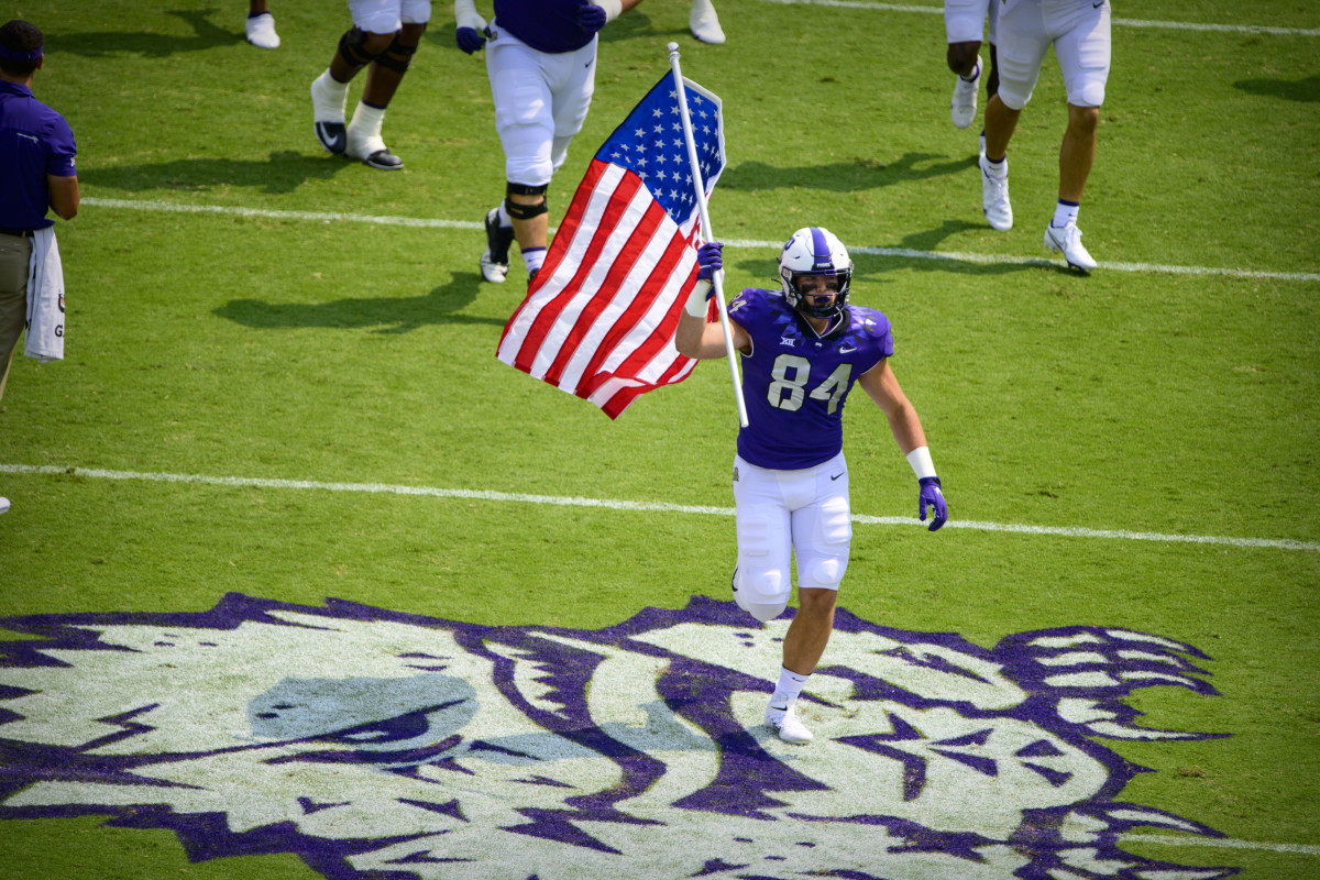 Sep 11, 2021; Fort Worth, Texas, USA; TCU Horned Frogs tight end Dominic DiNunzio (84) carries an American flag as he leads his team on to the field before the game between the TCU Horned Frogs and the California Golden Bears at Amon G. Carter Stadium.