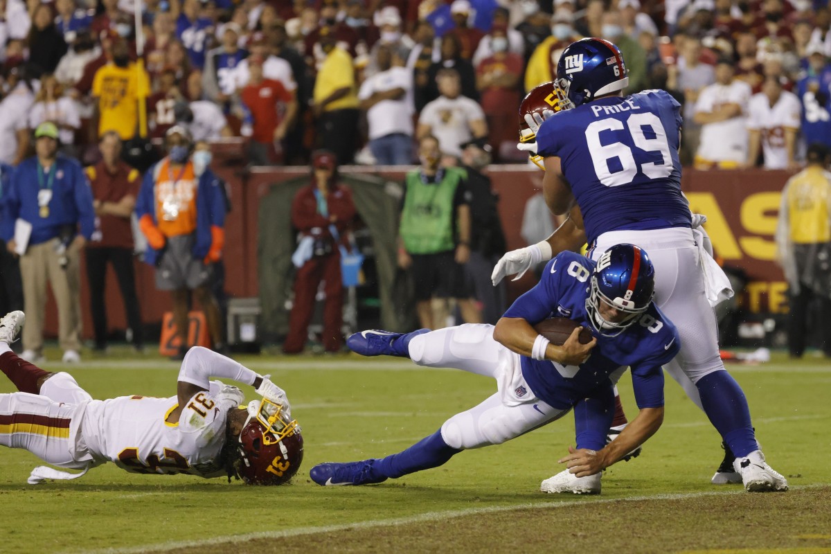 Sep 16, 2021; Landover, Maryland, USA; New York Giants quarterback Daniel Jones (8) runs for a touchdown as Washington Football Team safety Kamren Curl (31) attempts the tackle in the first quarter at FedExField.