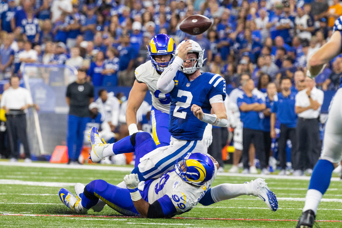 Sep 19, 2021; Indianapolis, Indiana, USA; Indianapolis Colts quarterback Carson Wentz (2) passes the ball while Los Angeles Rams defensive end Aaron Donald (99) defends in the second half at Lucas Oil Stadium. Indianapolis Colts quarterback Carson Wentz (2) did not return after this tackle. Mandatory Credit: Trevor Ruszkowski-USA TODAY Sports