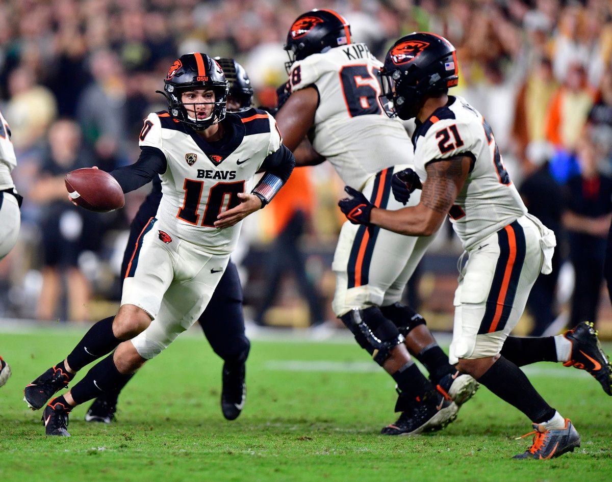 Oregon State quarterback Chance Nolan (10) hands the ball off to running back Trey Lowe (21).