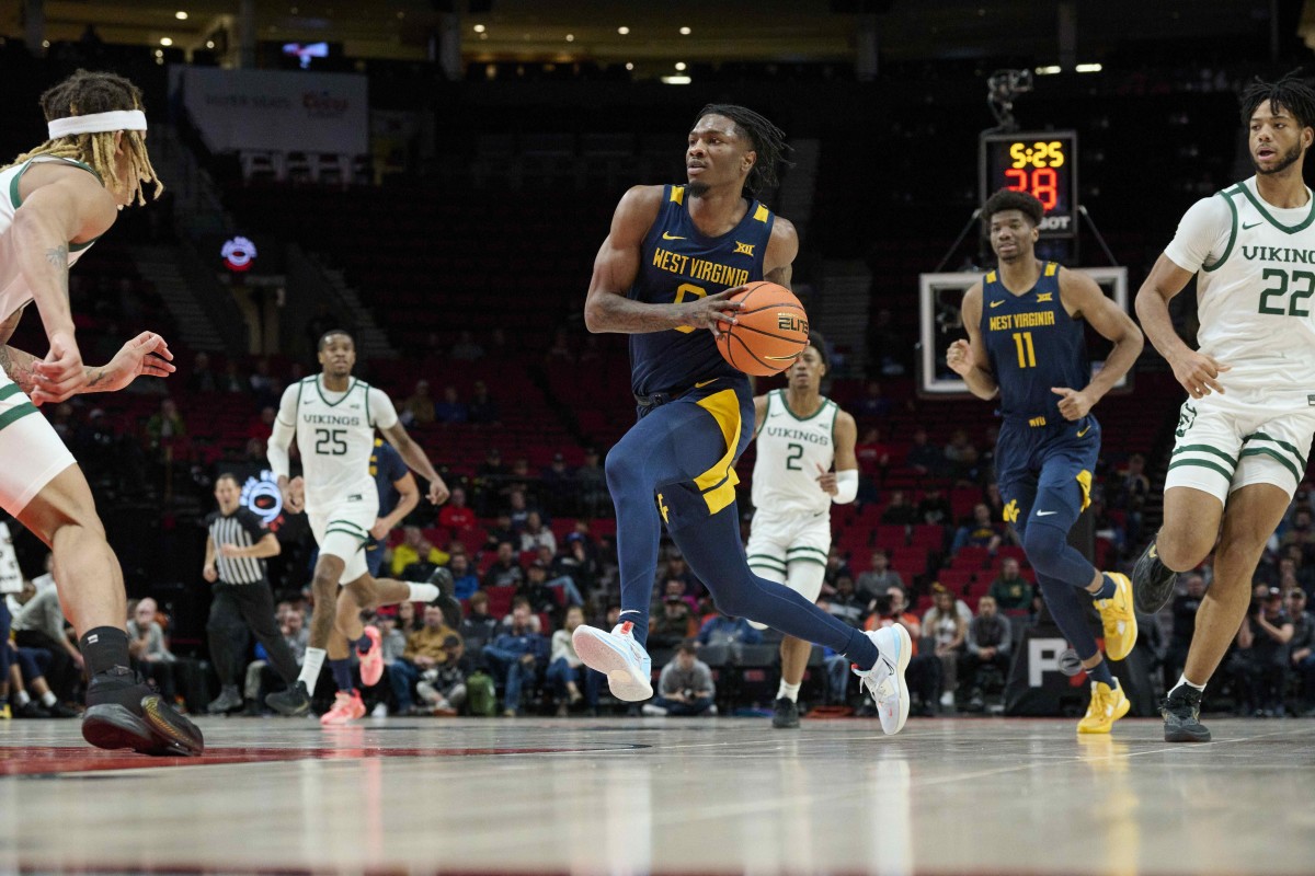 Nov 25, 2022; Portland, Oregon, USA; West Virginia Mountaineers guard Kedrian Johnson (0) takes the ball to the basket during the first half on a fast break against the Portland State Vikings at Moda Center.