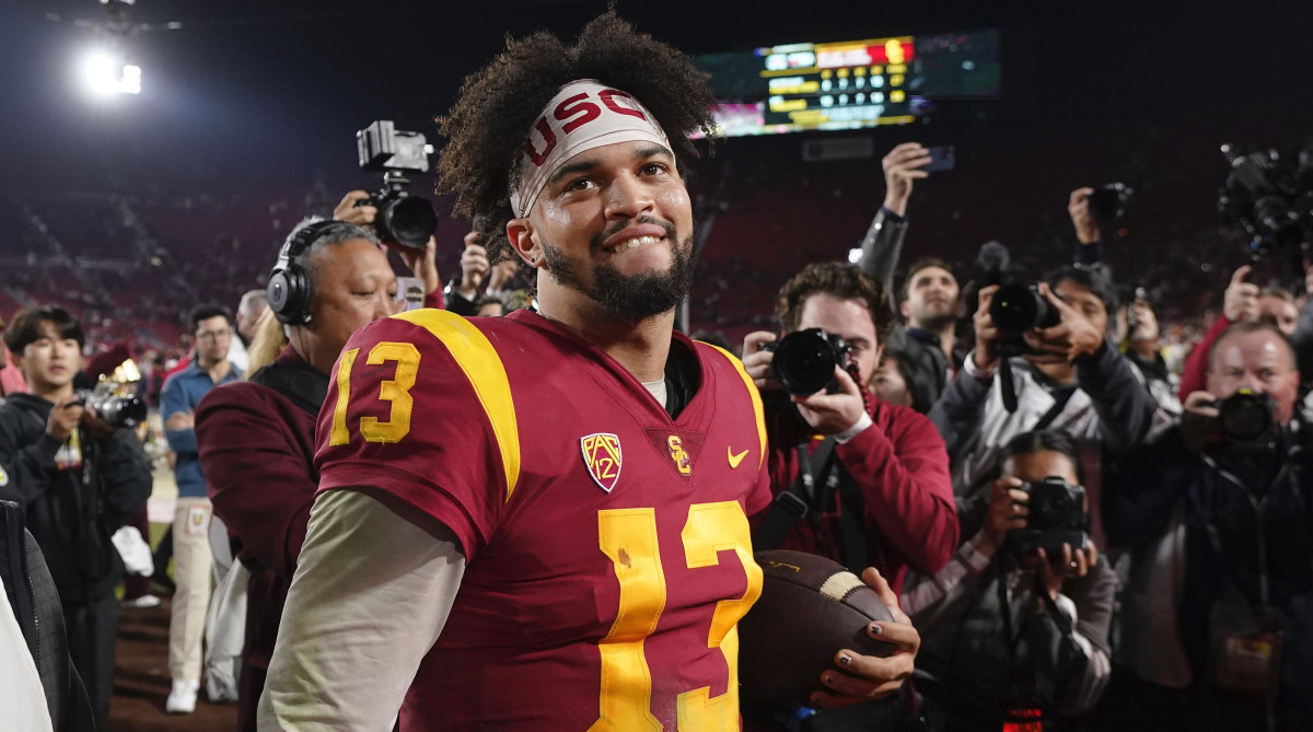 Caleb Williams smiles surrounded by cameras after USC defeated Notre Dame on Saturday, Nov. 26, 2022, in Los Angeles.