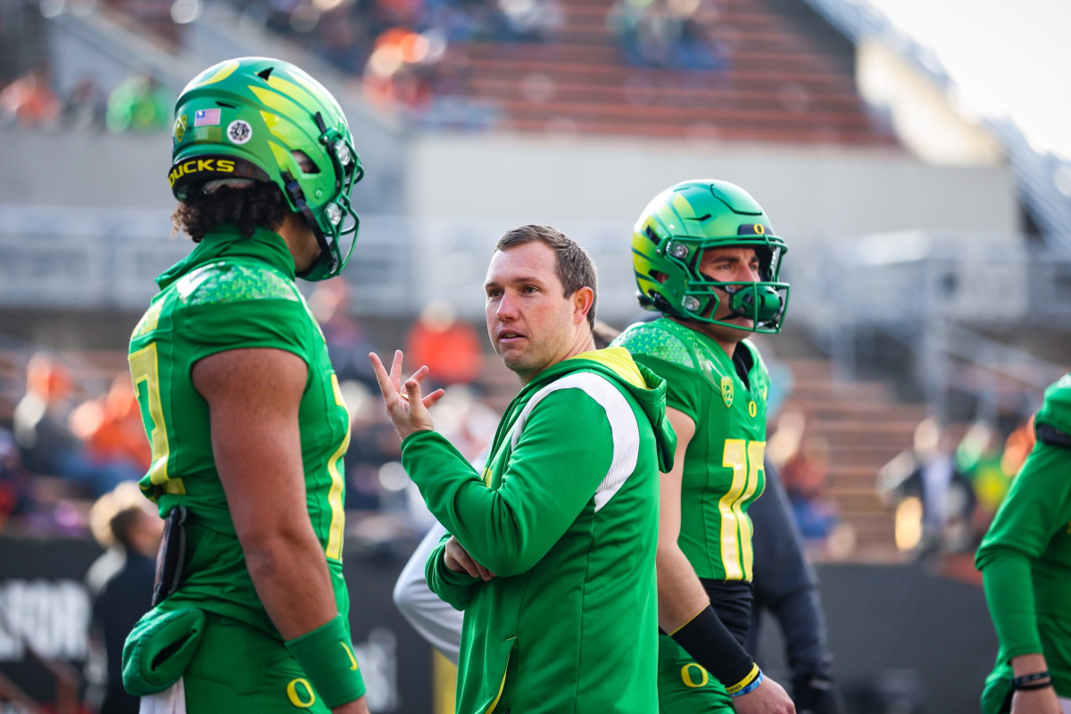 Kenny Dillingham talks with Ty Thompson on the field during pregame warmups against the Oregon State Beavers.