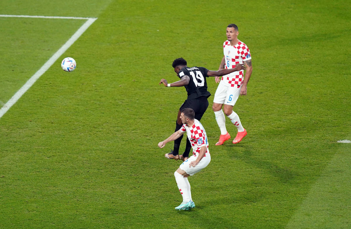 Alphonso Davies pictured heading the ball to score Canada's first ever goal at a FIFA Men's World Cup, against Croatia at Qatar 2022