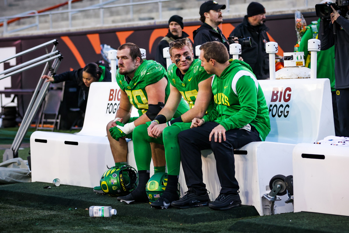 Kenny Dillingham sits with quarterback Bo Nix and offensive lineman Alex Forsyth following a 38-34 loss to the Oregon State Beavers in Corvallis.