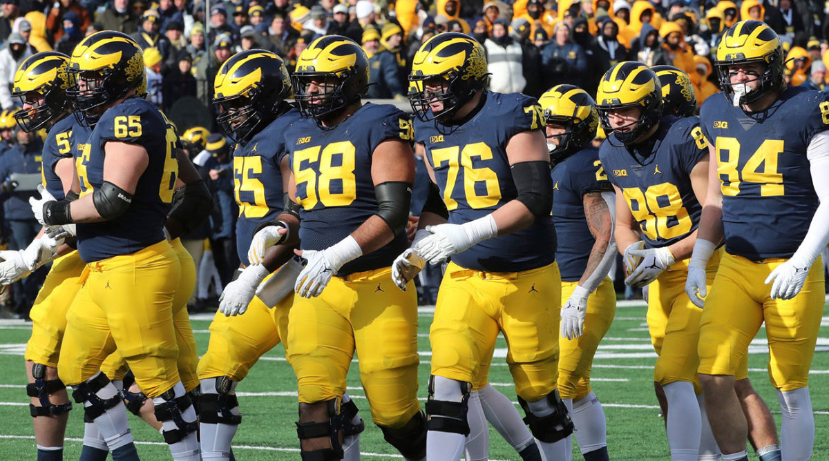 The Michigan offensive line breaks the huddle and moves to the line of scrimmage.