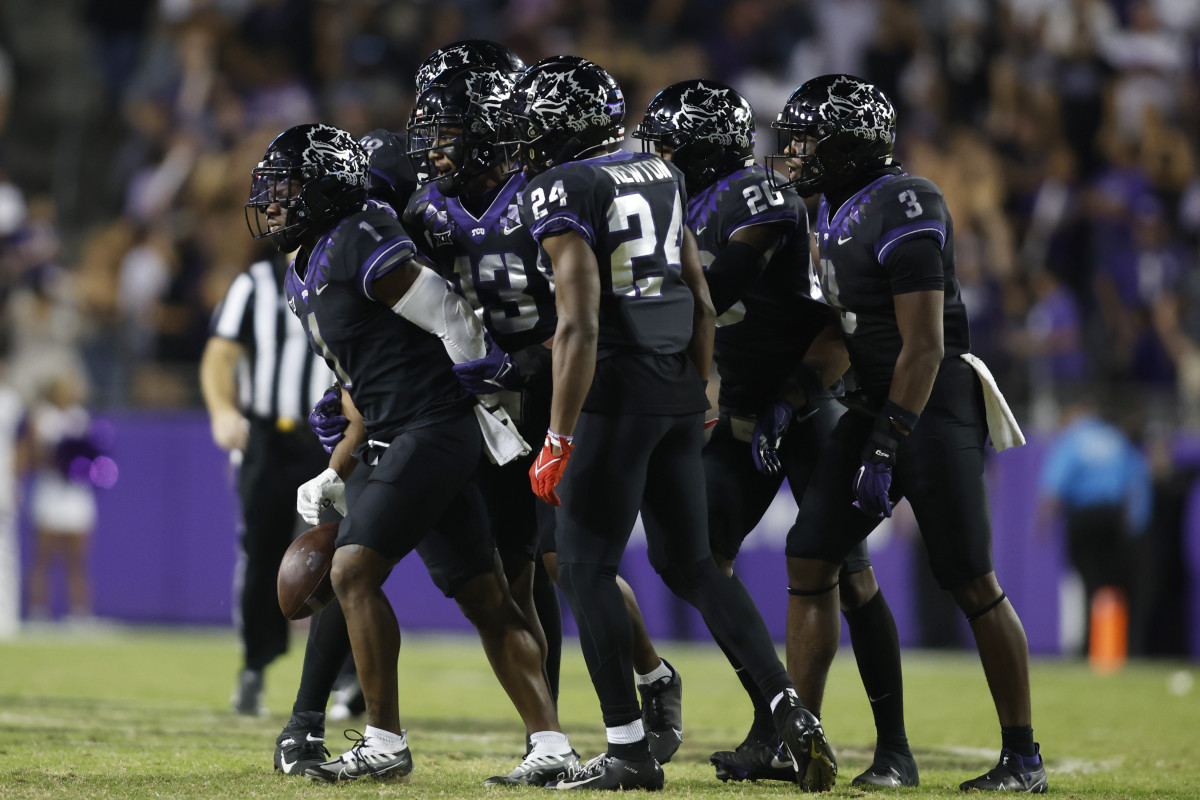 TCU Horned frog football players react in a huddle after an interception against the Kansas State Wildcats
