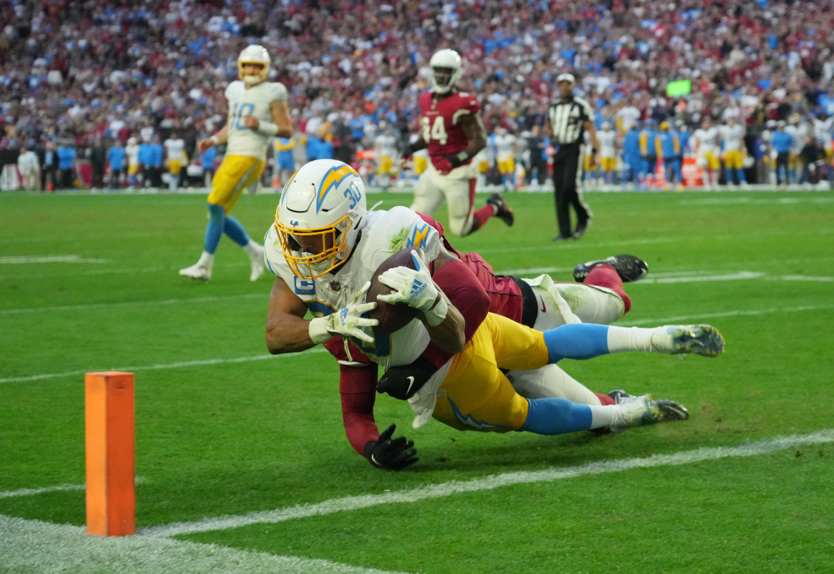 Los Angeles Chargers running back Austin Ekeler (30) scores a touchdown against Arizona Cardinals linebacker Isaiah Simmons (9) in the second half at State Farm Stadium.