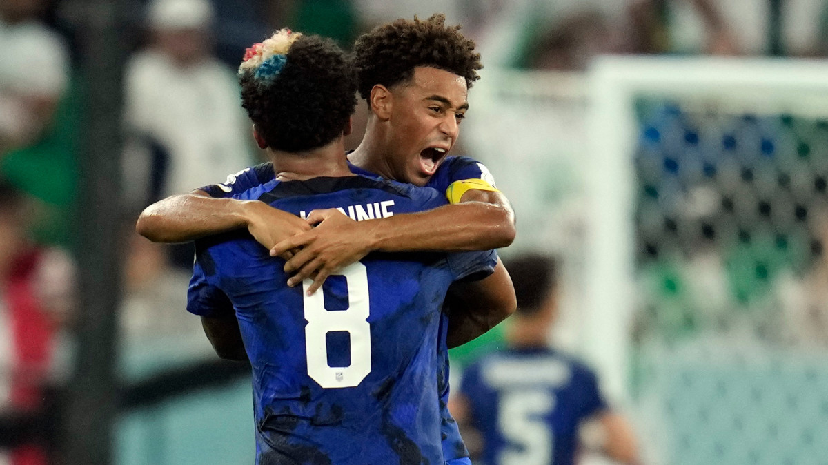 Tyler Adams and Weston McKennie celebrate the USA’s win over Iran