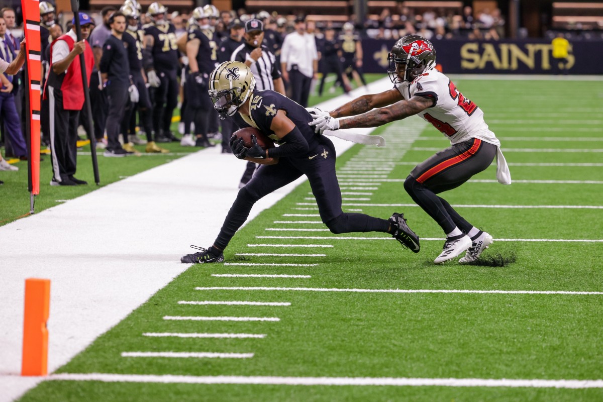 New Orleans Saints receiver Chris Olave (12) catches a pass against Tampa Bay Buccaneers cornerback Carlton Davis III (24). Mandatory Credit: Stephen Lew-USA TODAY Sports