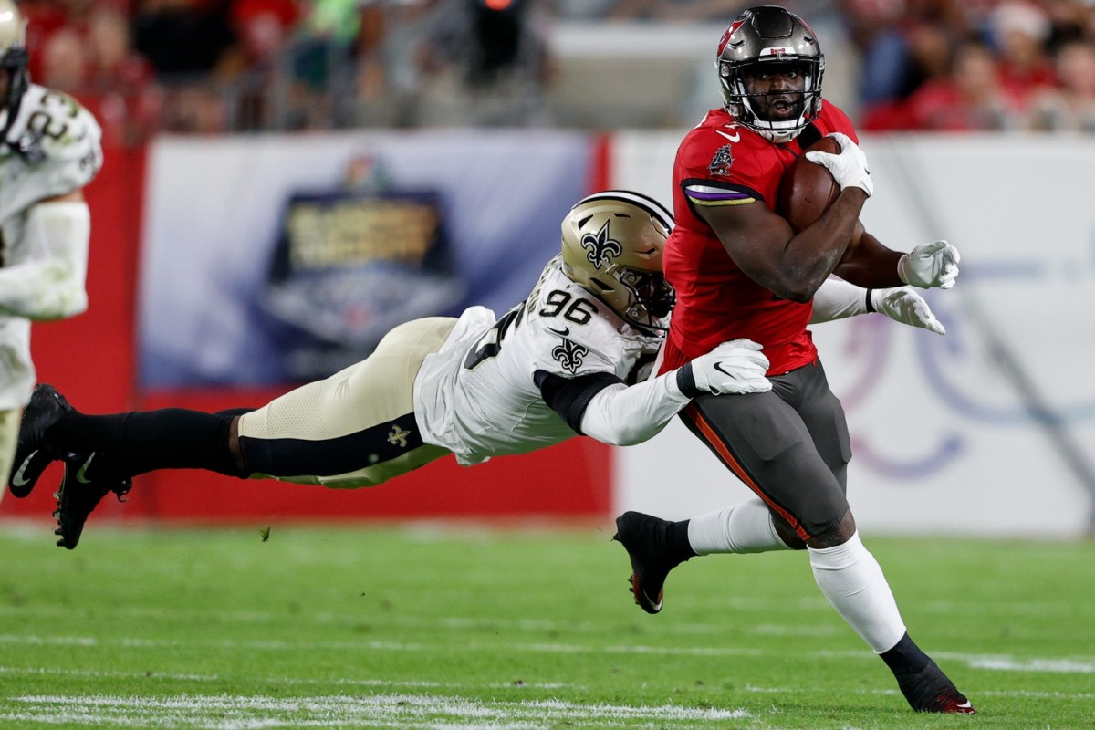 Dec 19, 2021; Tampa Bay Buccaneers running back Leonard Fournette (7) is tackled by New Orleans Saints defensive end Carl Granderson (96). Mandatory Credit: Nathan Ray Seebeck-USA TODAY Sports
