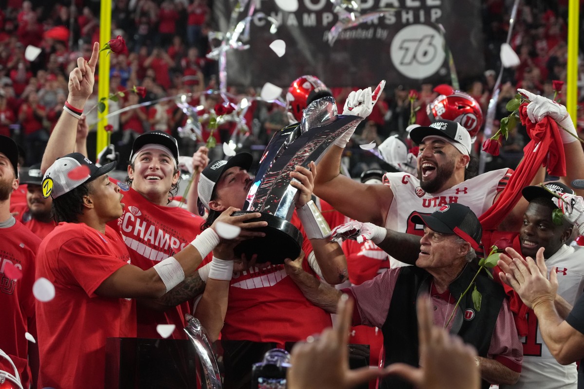 Utah Utes quarterback Cameron Rising hoists the Pac-12 Championship trophy after the game against the Southern California Trojans at Allegiant Stadium.