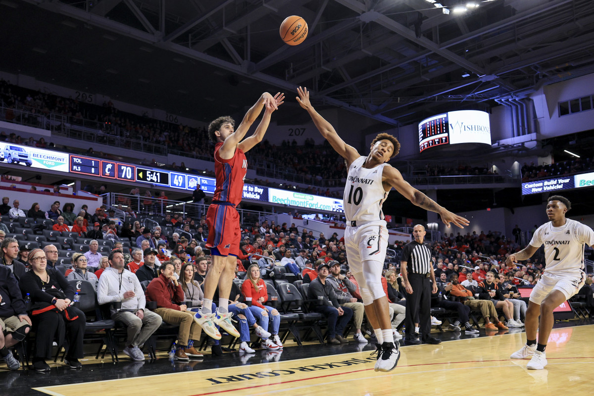 Nov 30, 2022; Cincinnati, Ohio, USA; N.J.I.T Highlanders guard Adam Hess (4) makes a three-point basket against Cincinnati Bearcats guard Rob Phinisee (10) in the second half at Fifth Third Arena. Mandatory Credit: Aaron Doster-USA TODAY Sports