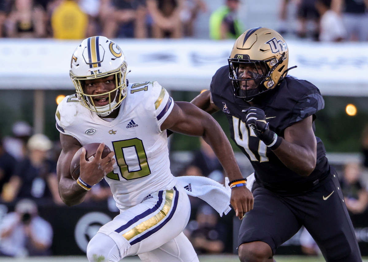 Sep 24, 2022; Orlando, Florida, USA; Georgia Tech Yellow Jackets quarterback Jeff Sims (10) carries the ball as UCF Knights defensive end K.D. McDaniel (47) moves in during the second half at FBC Mortgage Stadium. Mandatory Credit: Mike Watters-USA TODAY Sports