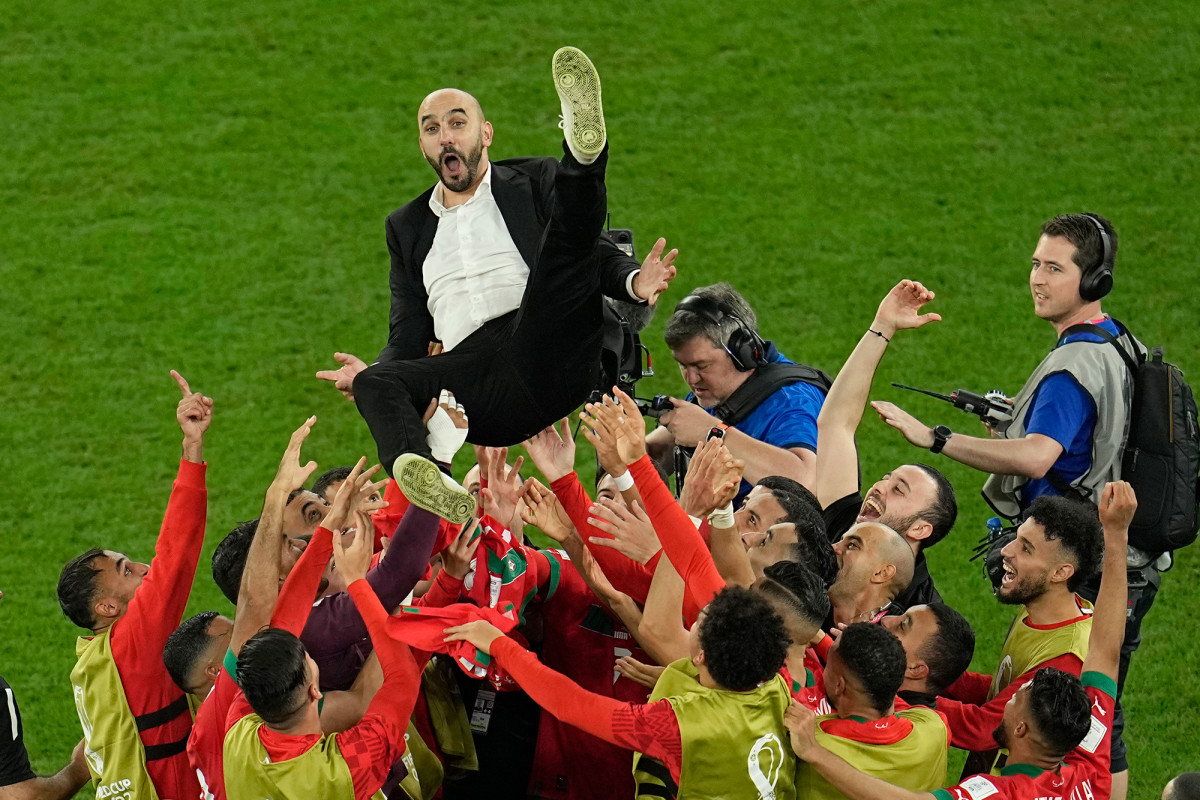 Morocco players hoist manager Walid Regragui after a last-16 win over Spain