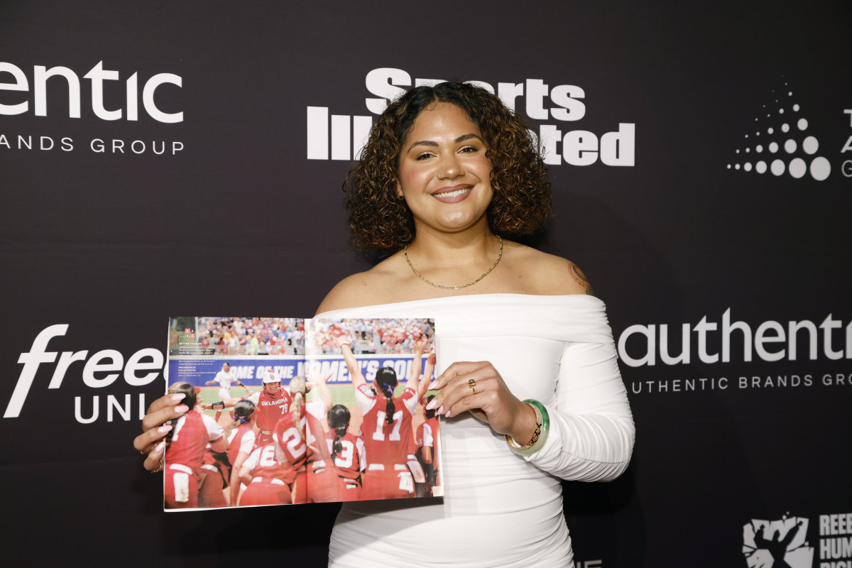 Jocelyn Alo poses with a copy of Sports Illustrated on the red carpet at the Sports Illustrated Awards.