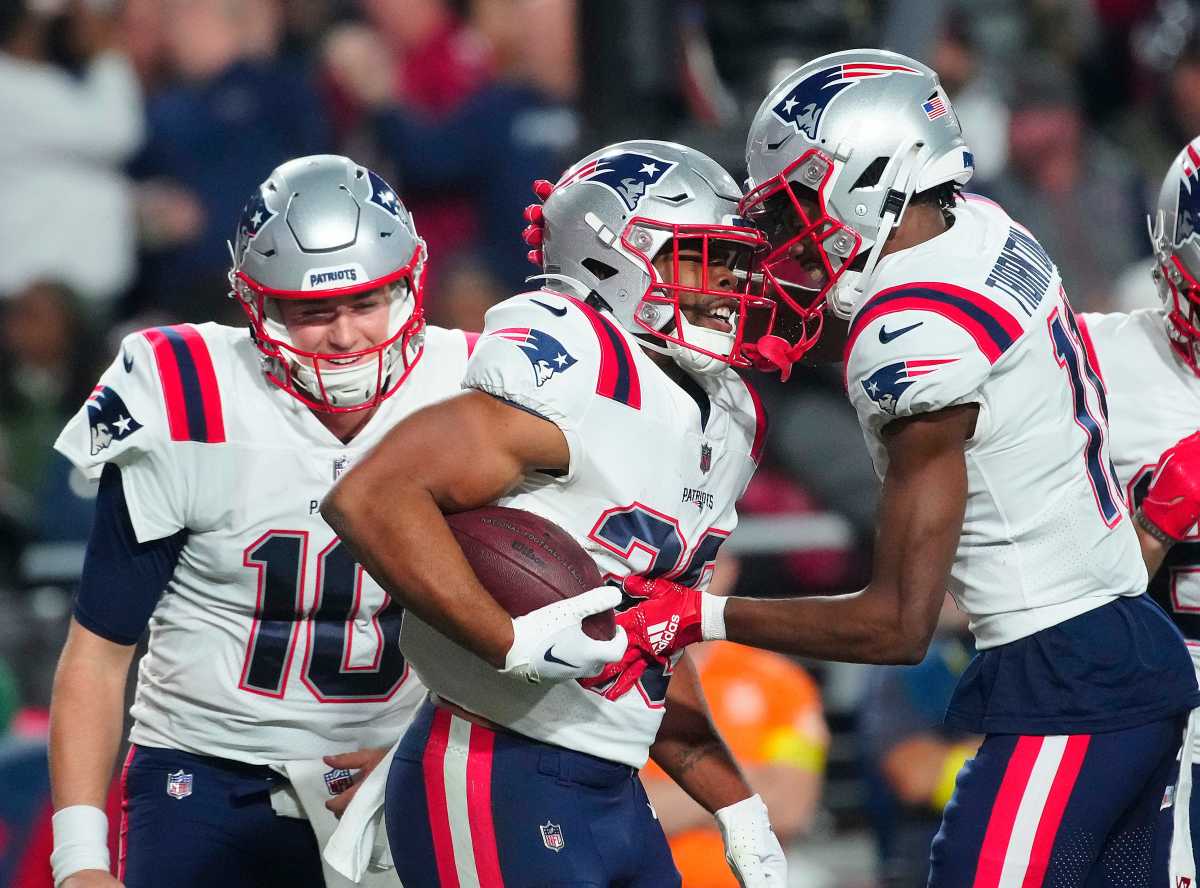 Patriots Mac Jones (10) and Kevin Harris (26) celebrate a rushing touchdown against the Cardinals during the first half of a game at State Farm Stadium.