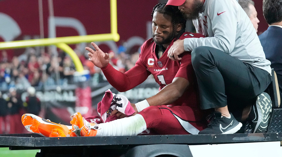 Cardinals quarterback Kyler Murray (1) waves as he s carted off the field after an injury against the Patriots during the first quarter at State Farm Stadium.