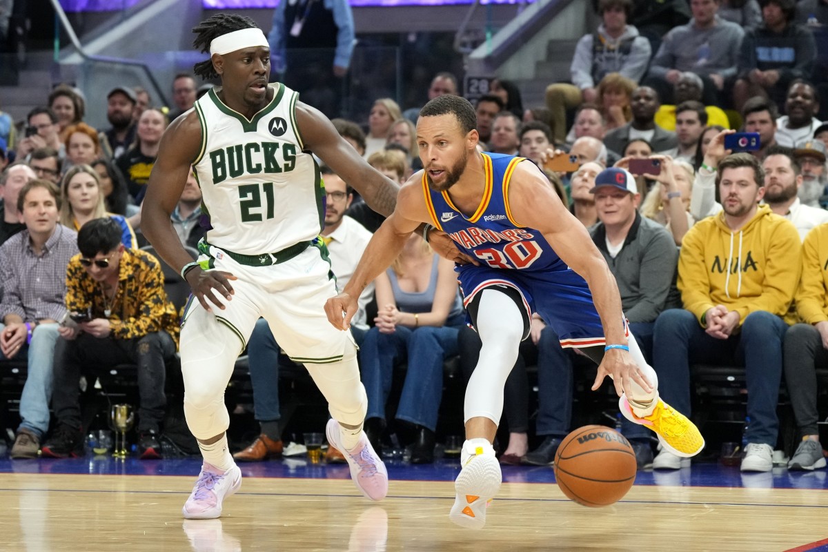 Golden State Warriors guard Stephen Curry (30) dribbles against Milwaukee Bucks guard Jrue Holiday (21)