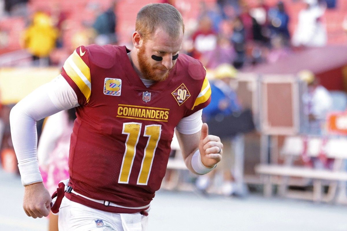 Washington Commanders quarterback Carson Wentz (11) jogs off the field after the Commanders' game against the Tennessee Titans at FedExField.