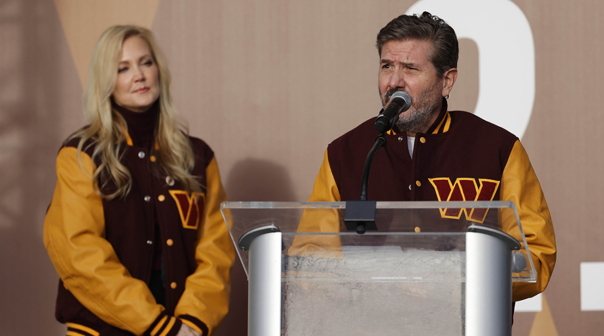 Commanders co-owner Dan Snyder speaks as co-owner Tanya Snyder (L) listens during a press conference revealing the Commanders as the new name for the formerly named Washington Football Team at FedEx Field.
