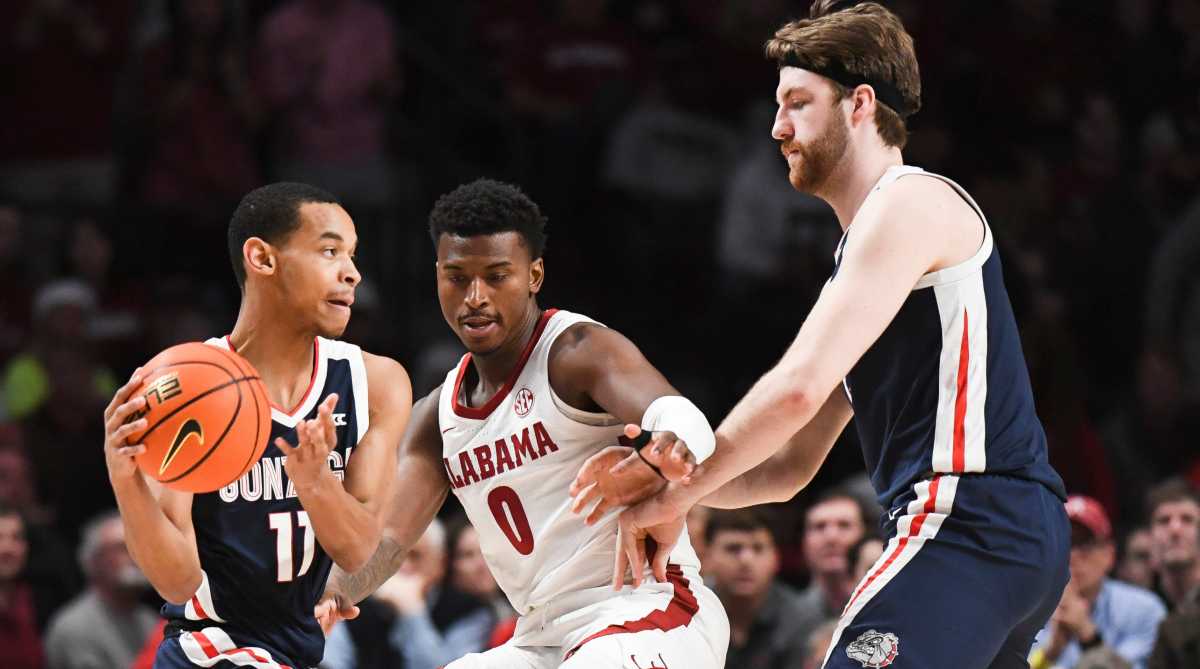 Alabama guard Jaden Bradley tries to work through a screen by Gonzaga forward Drew Timme as he defends Gonzaga guard Nolan Hickman.
