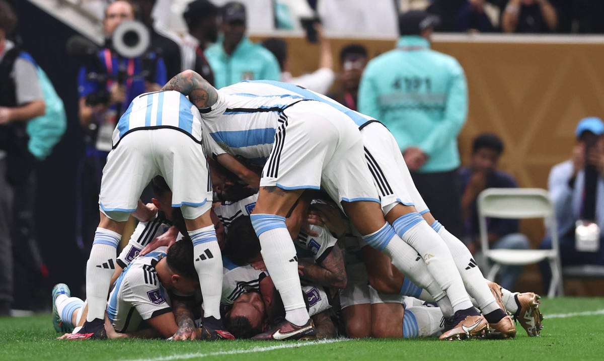 Argentina players pictured piling on top of Lionel Messi after his penalty goal against France in the 2022 FIFA World Cup final