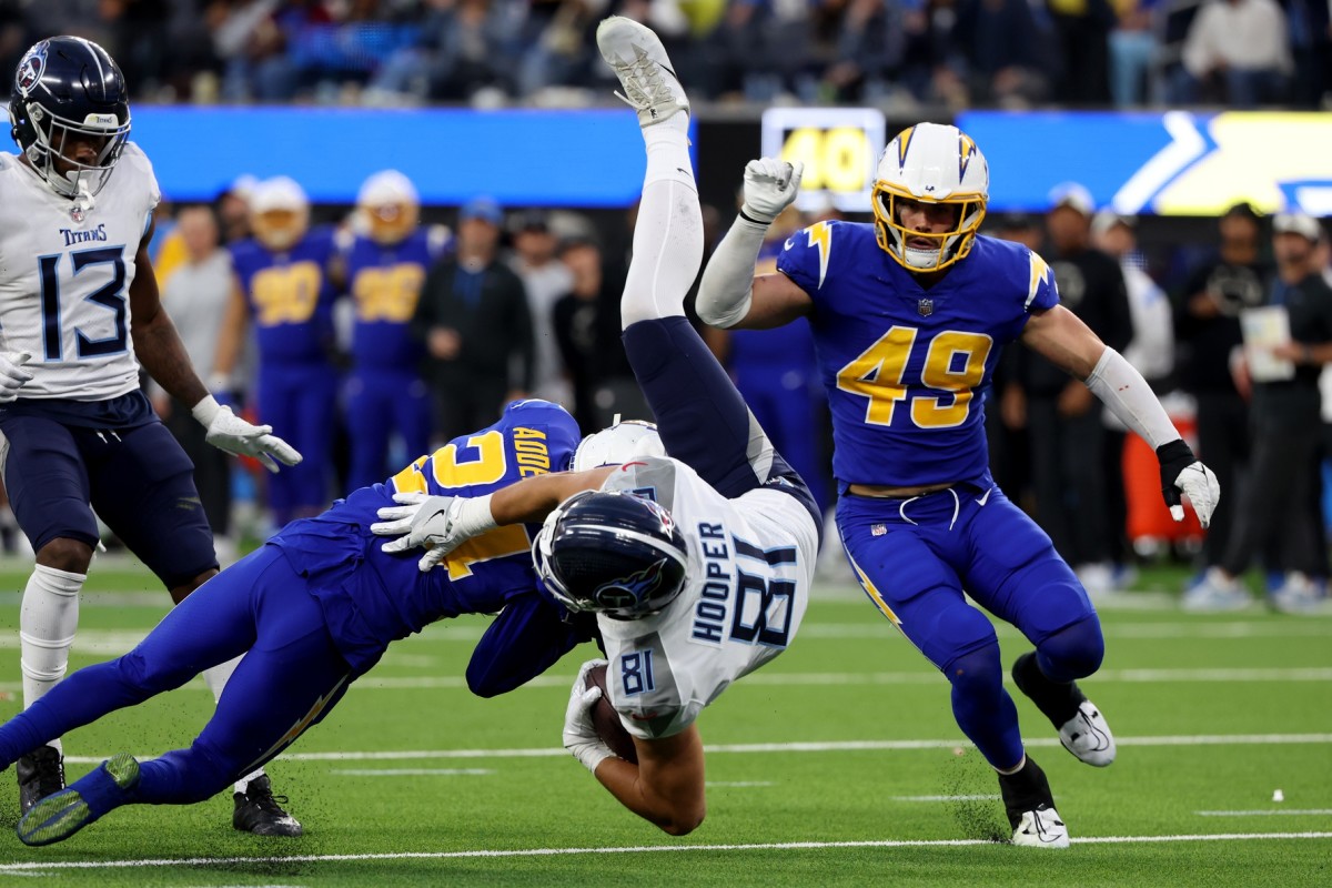 Tennessee Titans tight end Austin Hooper (81) is tackled by Los Angeles Chargers safety Nasir Adderley (24) during the fourth quarter at SoFi Stadium.
